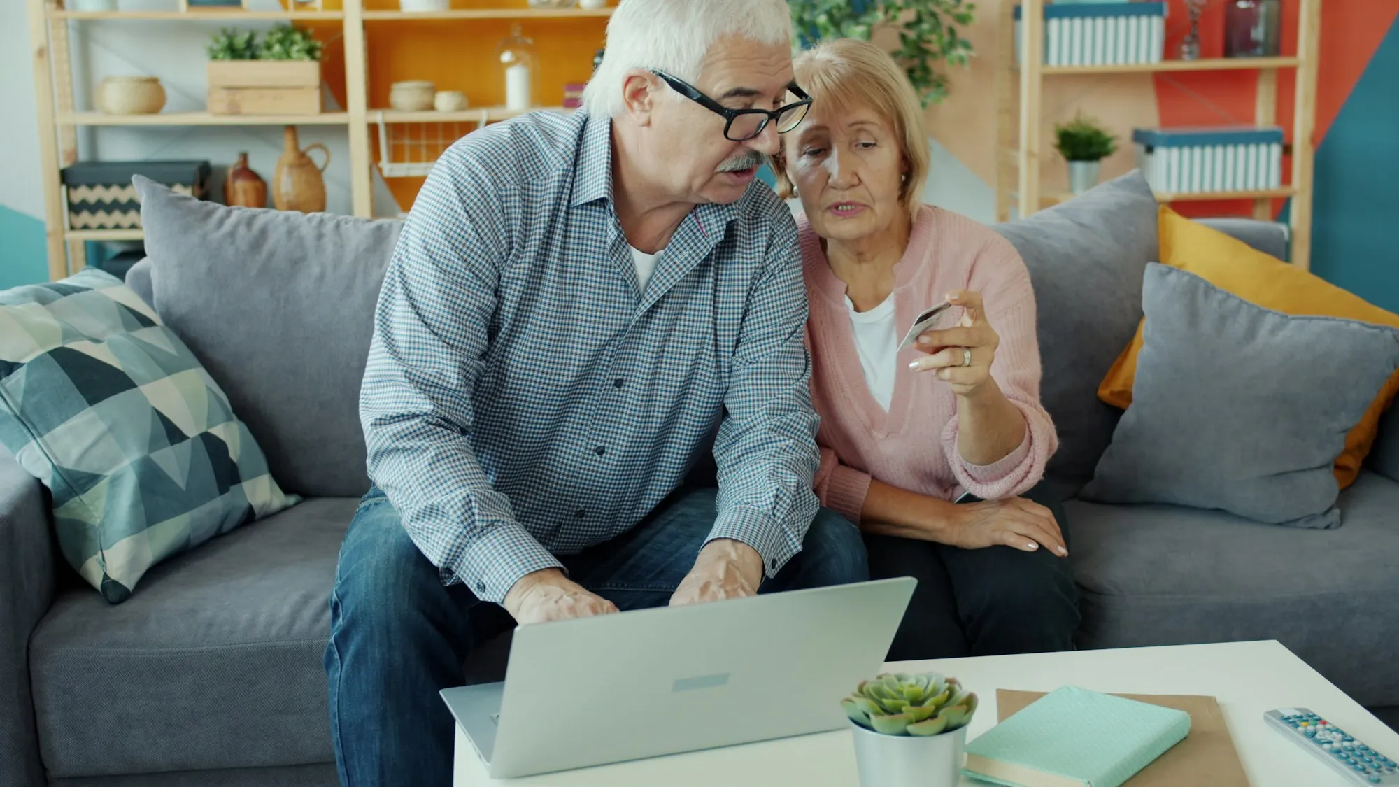 Older couple discussing something at a laptop
